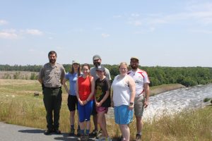 From left, Francis Ferrell of the U.S. Army Corps of Engineers, Sarah Hey, Linnea Lieth, Mario Marzan, Lea Wright, Katy Folk and Robert Williams. The group is standing in front of the Haw River, on the other side of Jordan Lake dam. (photo by Kim Spurr)