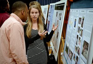 Judge Darius Scott, left, listens as Courtney Shepard explains her research at the Celebration of Undergraduate Research