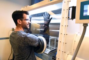 Assistant Professor Frank Leibfarth uses a newly-installed glovebox for the first time in his renovated space in Kenan Labs. (Photo by Melanie Busbee) 