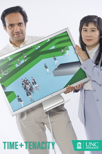 Dinesh Manocha (left) and Ming Lin hold a computer showcasing a modeling and simulation program called OneSAF (One Semi-Automated Forces), a defense technology and simulation tranining they developed to teach soldiers how to stay alive in the combat zone. (photo by Steve Exum)