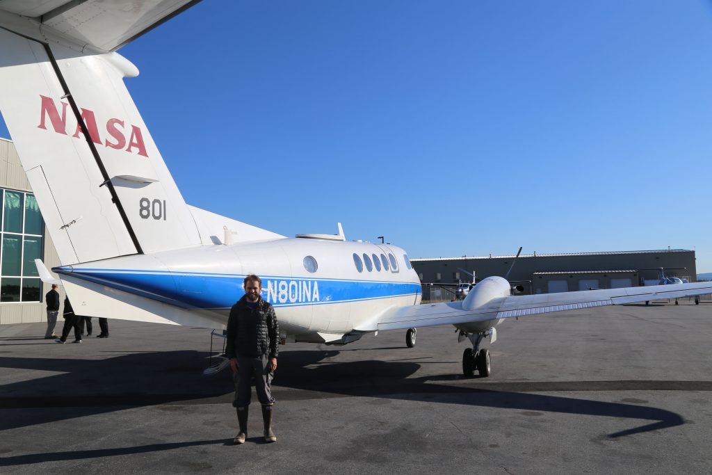 UNC hydrologist Tamlin Pavelsky stands in front of a NASA KingAir B200, which houses the AirSWOT suite of instruments. Scientists including Pavelsky are using AirSWOT to provide new measurements of surface water and ocean topography. (photo courtesy of Tamlin Pavelsky)
