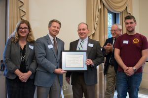Dean Kevin Guskiewicz (center, left) presents a distinguished professorship certificate to Chris Clemens. (photo by Kristen Chavez