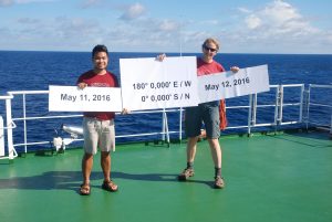 John Paul Balmonte ’17 Ph.D. and adviser Carol Arnosti, professor in the Department of Marine Sciences, stand at the Equator and Prime Meridian in the Pacific Ocean aboard the BacGeoPac cruise in the summer of 2016.