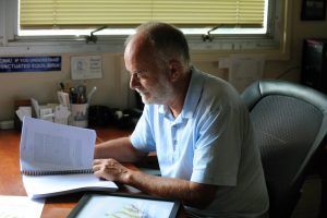 Baumgartner reviews a galley copy of the book in his office in Hamilton Hall. (photo by Donn Young)